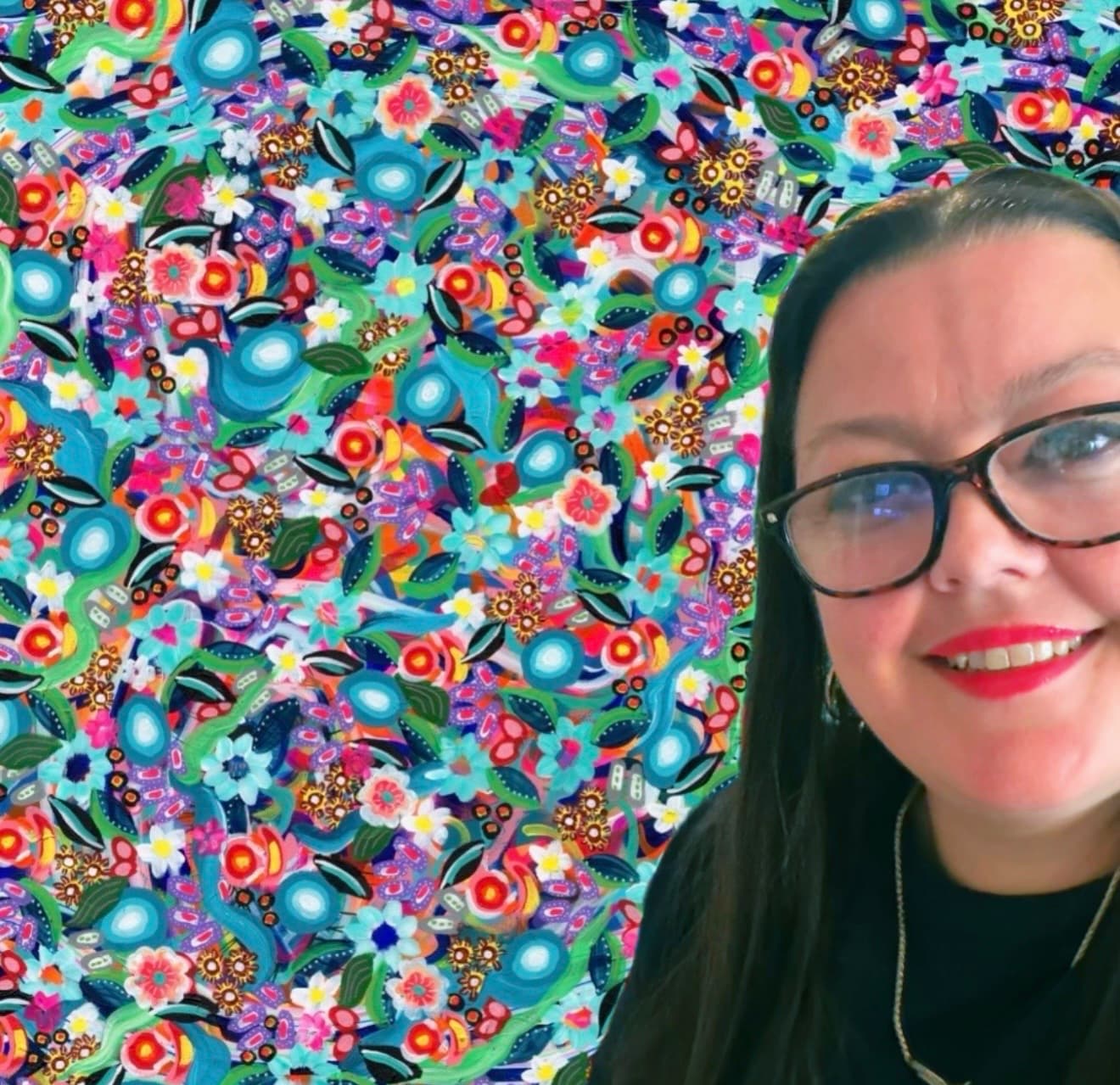 Stephanie Decker in front of a colourful floral painting